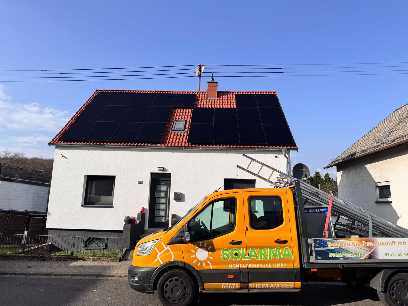 Vom Solarma-Team installierte Photovoltaik-Anlage auf einem Einfamilienhaus, davor der Solarma-Montagewagen